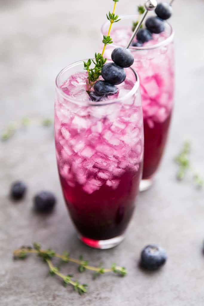 Close up view of a gin cocktail with fresh blueberries.
