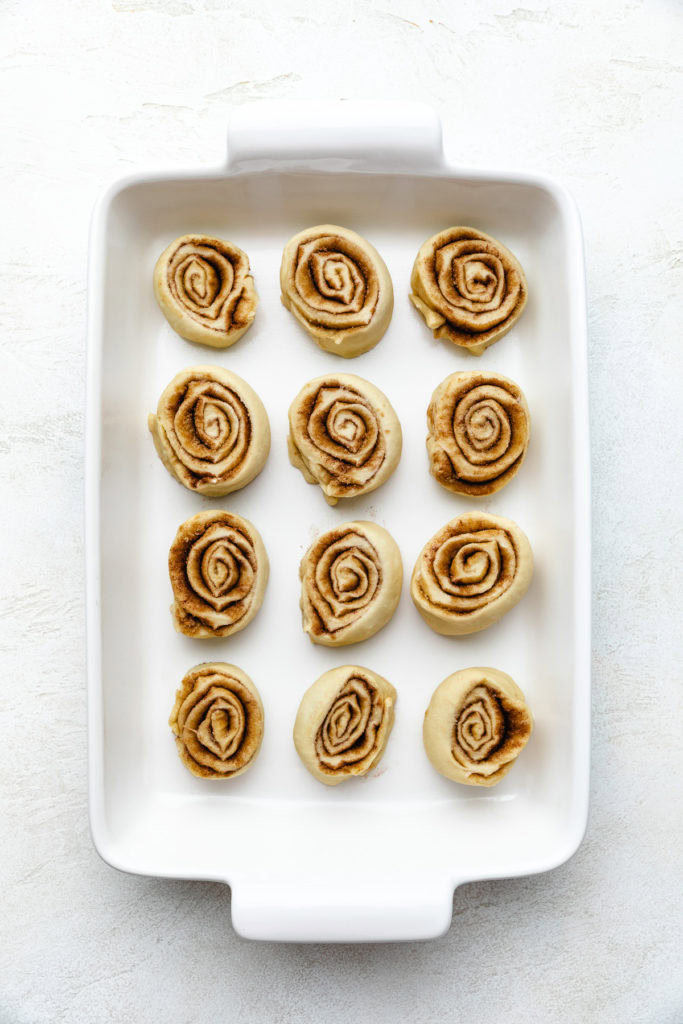 Unbaked cinnamon buns in a pan.