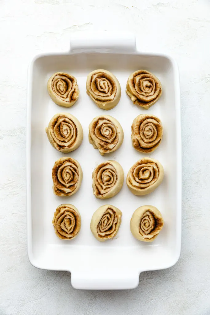 Unbaked cinnamon buns in a pan.