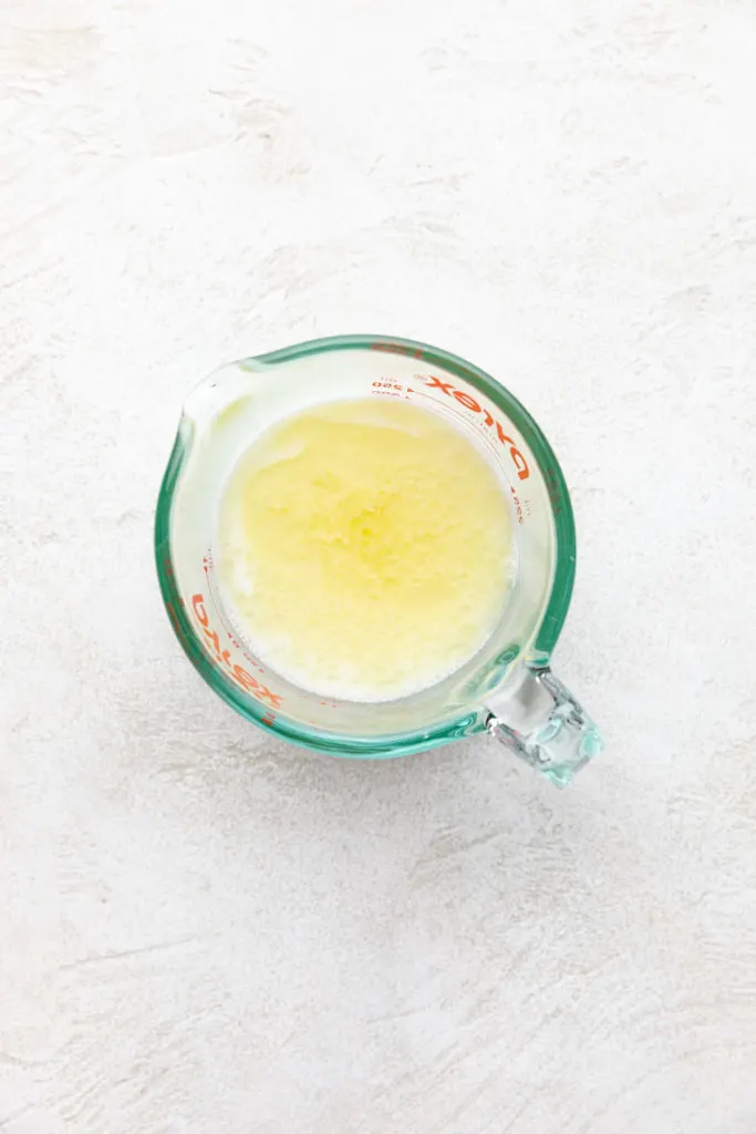 Melted butter, milk and water in a measuring cup.