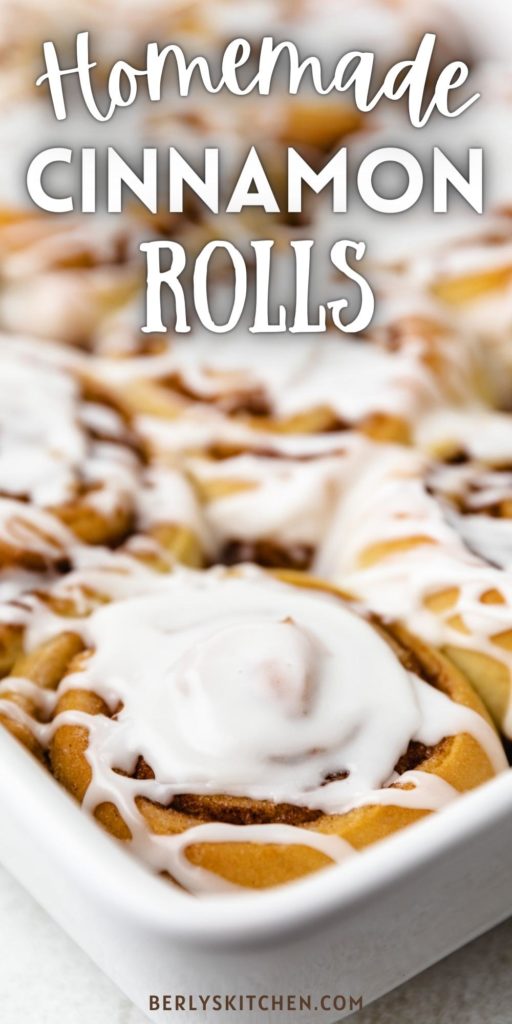 Close up view of a white pan with cinnamon buns.