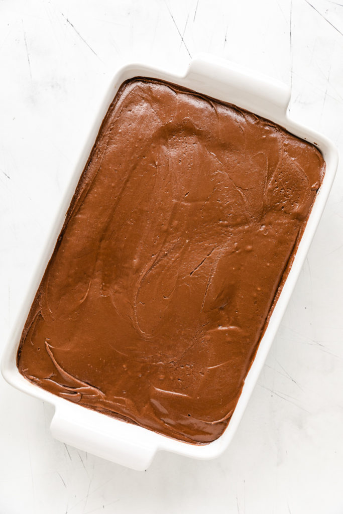 Top down view of an fudge icing on coke cake.