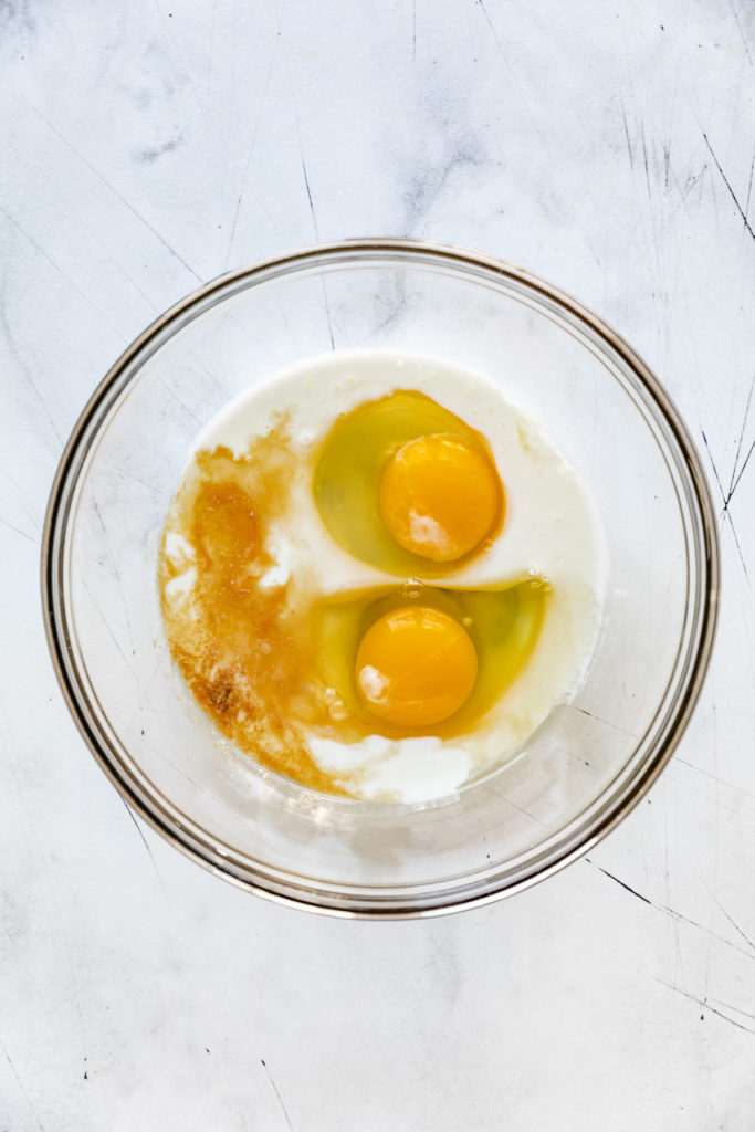 Eggs, buttermilk, and vanilla in a bowl.