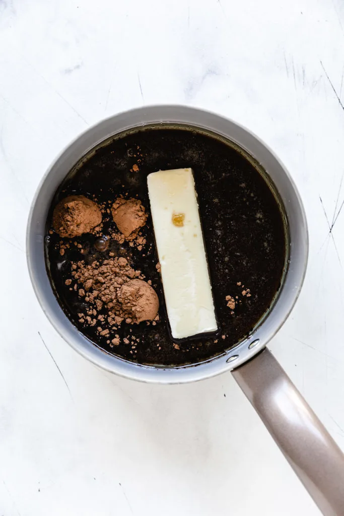 Butter, cocoa, cola, and oil in a pan.