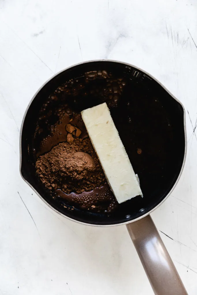 Butter, cola and cocoa in a saucepan.