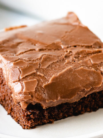 Close up view of a slice of coca-cola cake on two plates.