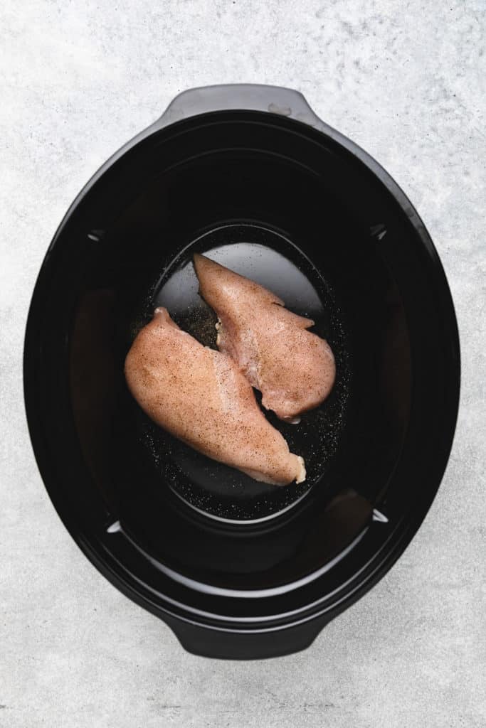 Seasoned chicken breasts in a slow cooker.