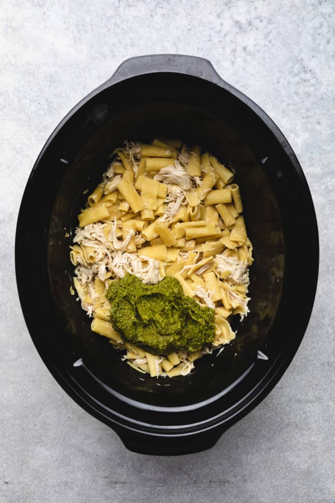 Noodles and pesto in a slow cooker.