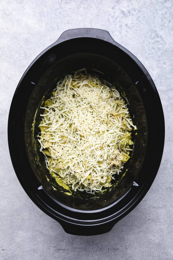 Shredded cheese on top of pasta in a crockpot.