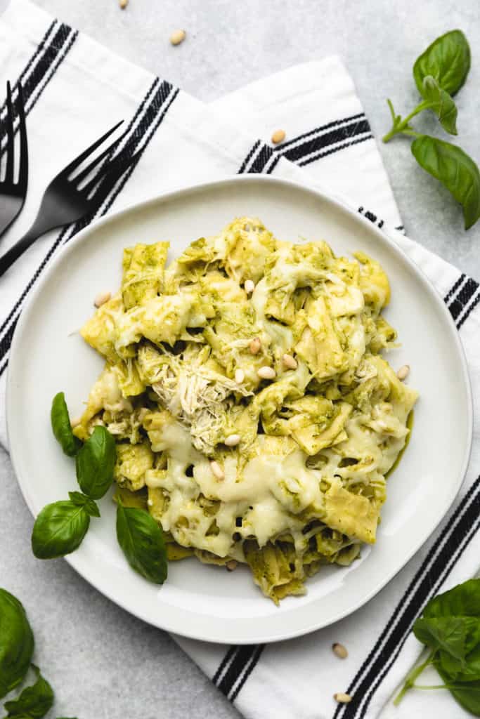 Top down view of pasta with pesto sauce on a plate.