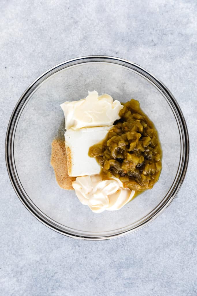 Cream cheese, mayo, green chiles, and spices in a bowl.