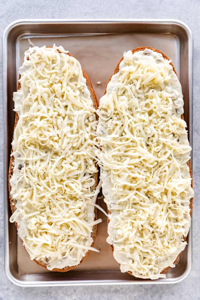 Cheese sprinkled over cheese bread.
