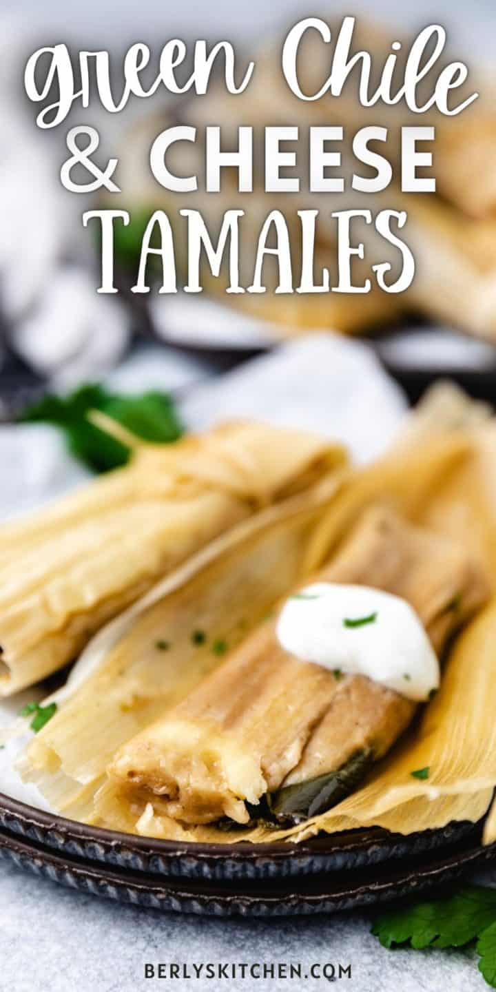 Green chile and cheese tamales on stacked plates.