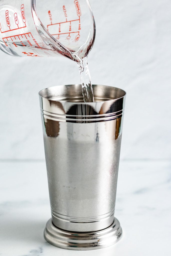 Coconut flavored rum being added to a shaker cup.