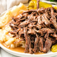 Close up view of pot roast and mashed potatoes.