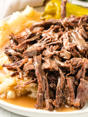 Close up view of pot roast and mashed potatoes.