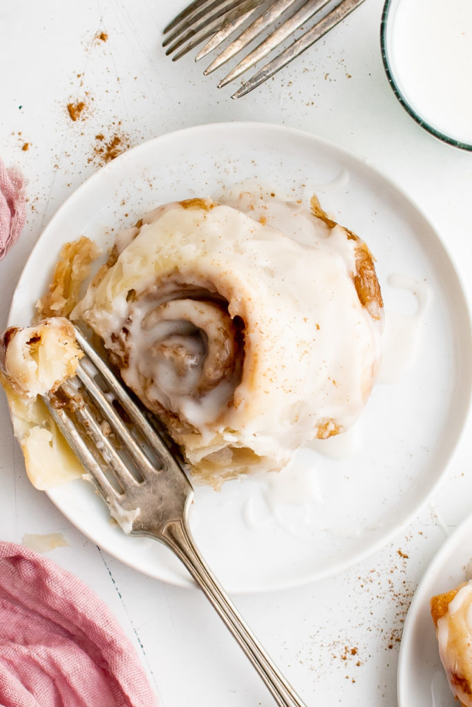 Top down view of a puff pastry cinnamon roll with glaze.