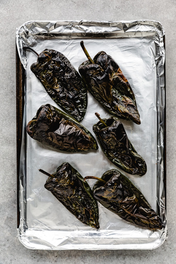 Blistered tamales on a baking sheet.