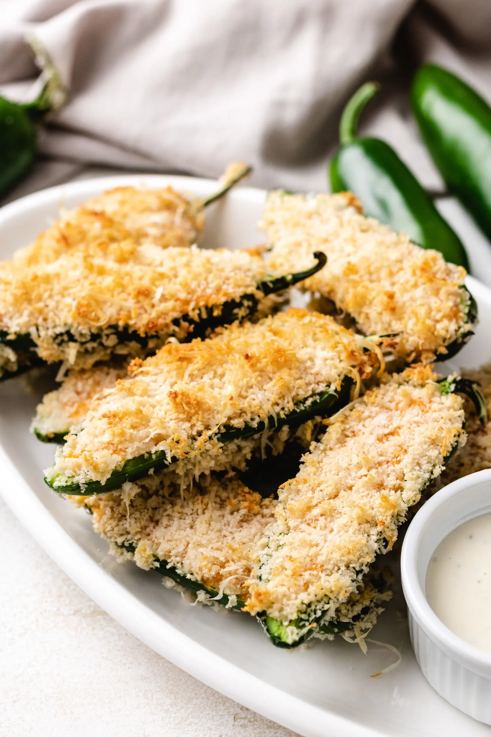 Side view of stuffed jalape&ntilde;os on a plate.