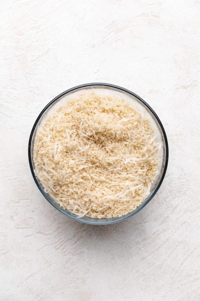 Parmesan cheese and breadcrumbs stirred together in a dish.