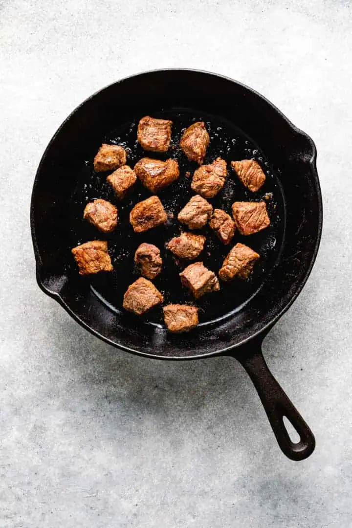 Cooked cubed beef in cast iron.