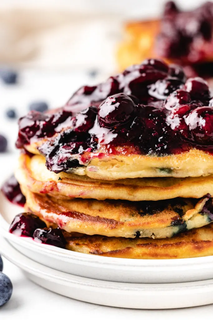 Blueberry Pancakes Close up view of a stack of blueberry pancakes with compote.