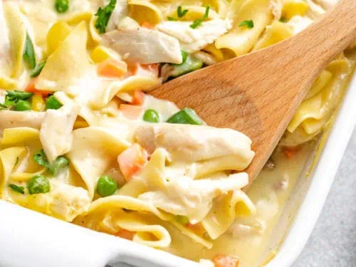 Close up view of creamy chicken noodle casserole in a casserole dish.