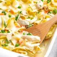 Creamy chicken noodle casserole in a white baking dish.