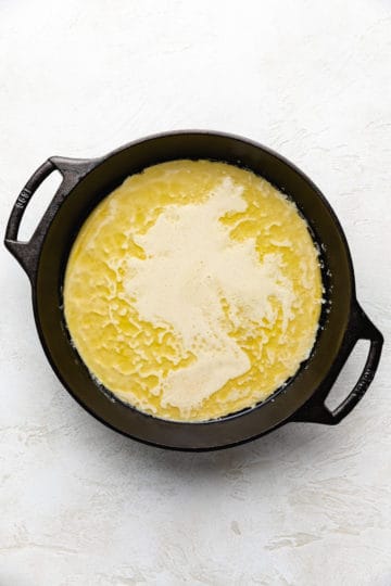 Pancake batter poured into a pan of hot, melted butter.