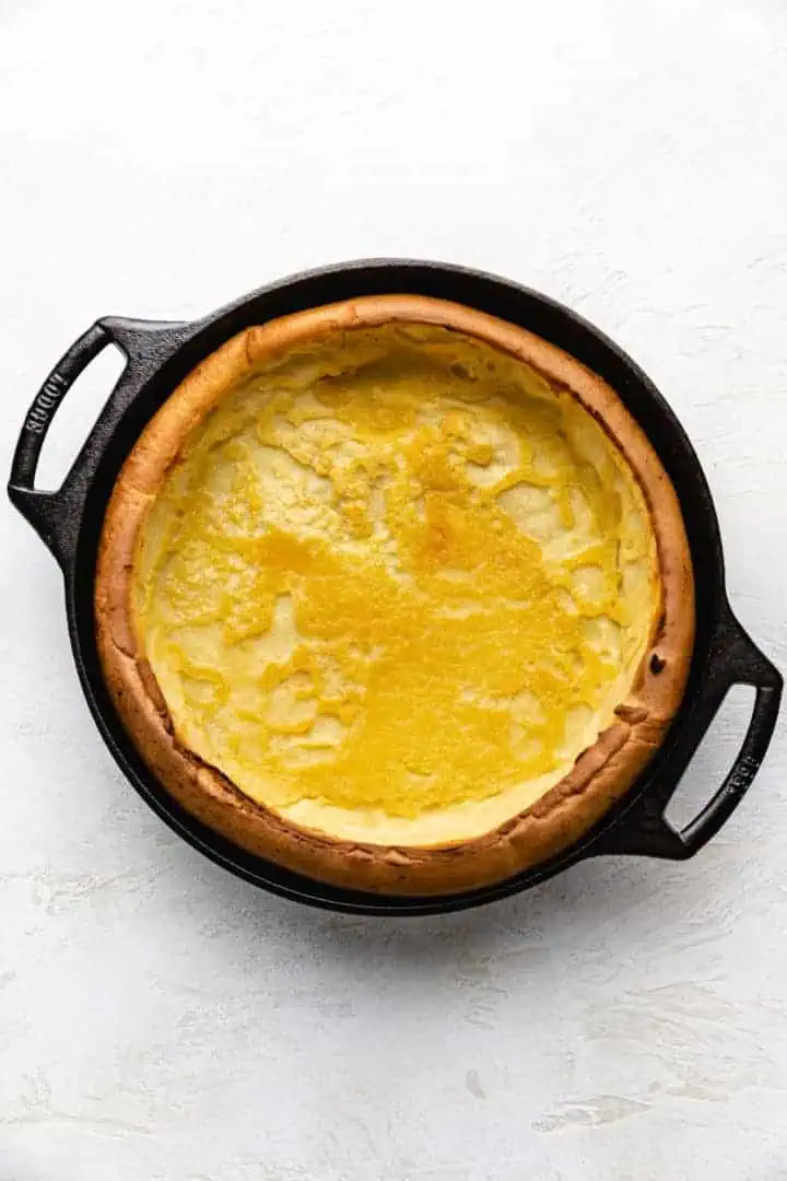 Top down view of a puffy pancake in cast iron.