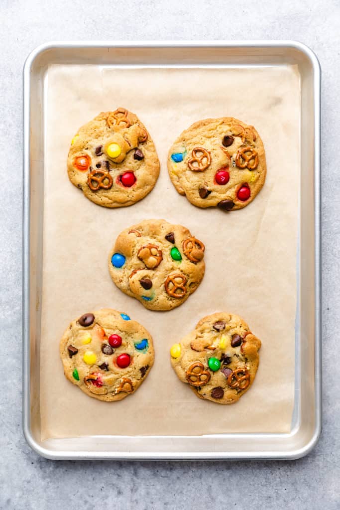 Five cookies on a baking sheet.