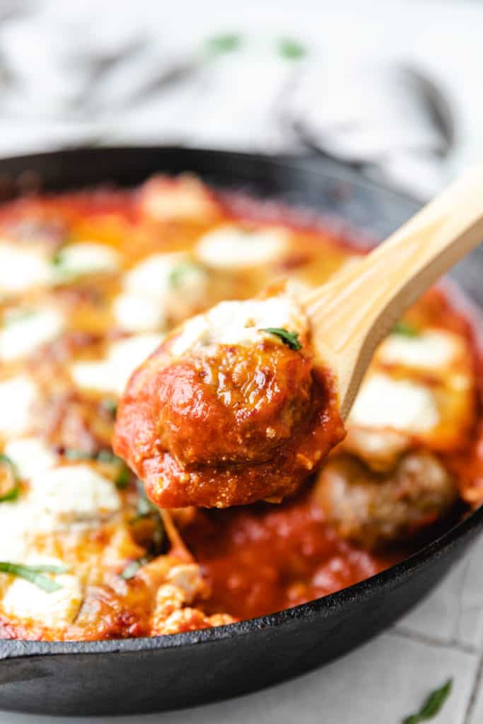 Spoon holding up a baked meatball.