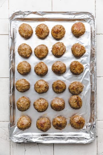 Baked meatballs on a baking sheet.