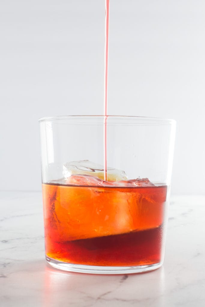 Campari being poured into a glass.