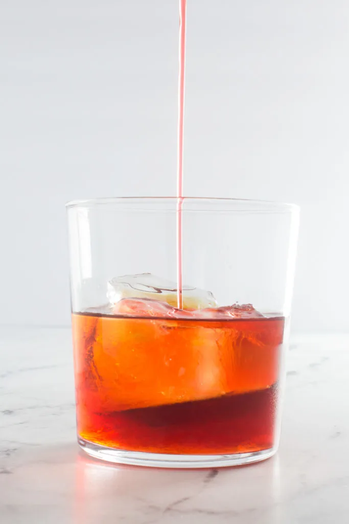 Campari being poured into a glass.