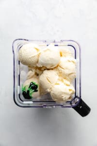 Ingredients for a green milkshake in a blender.