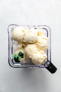 Ingredients for a green milkshake in a blender.