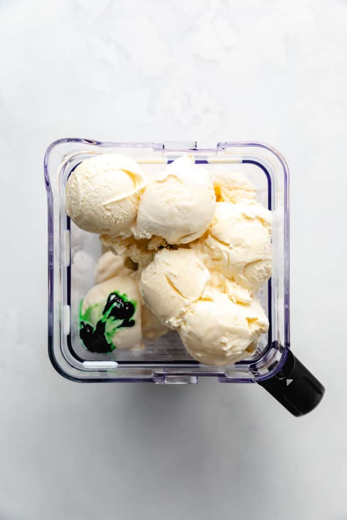 Ingredients for a green milkshake in a blender.