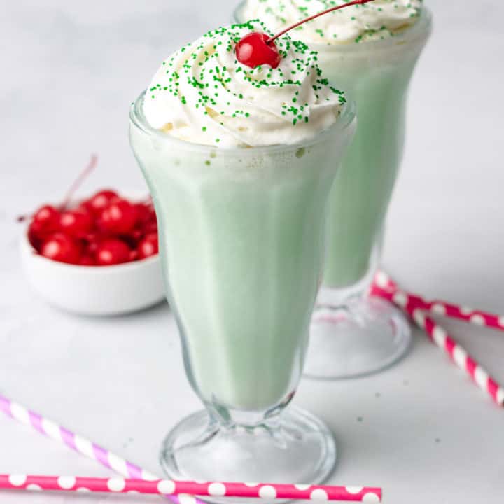 Close up view of two glasses filled with a copycat shamrock shake.