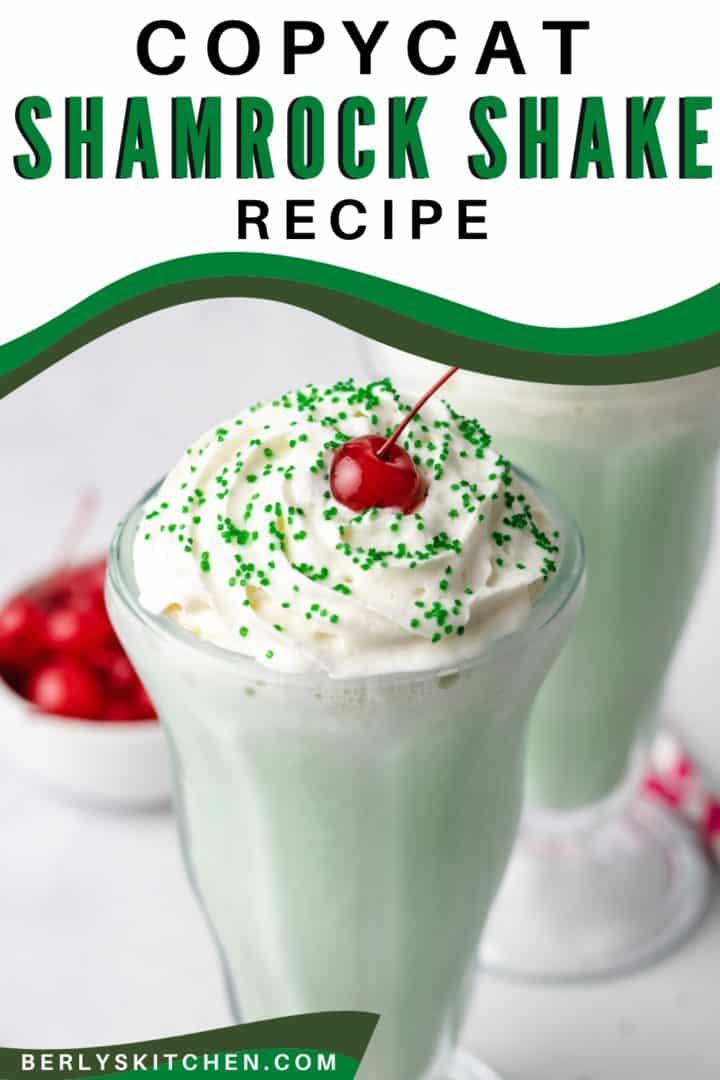 Cherry and whipped cream on top of a mint shake.