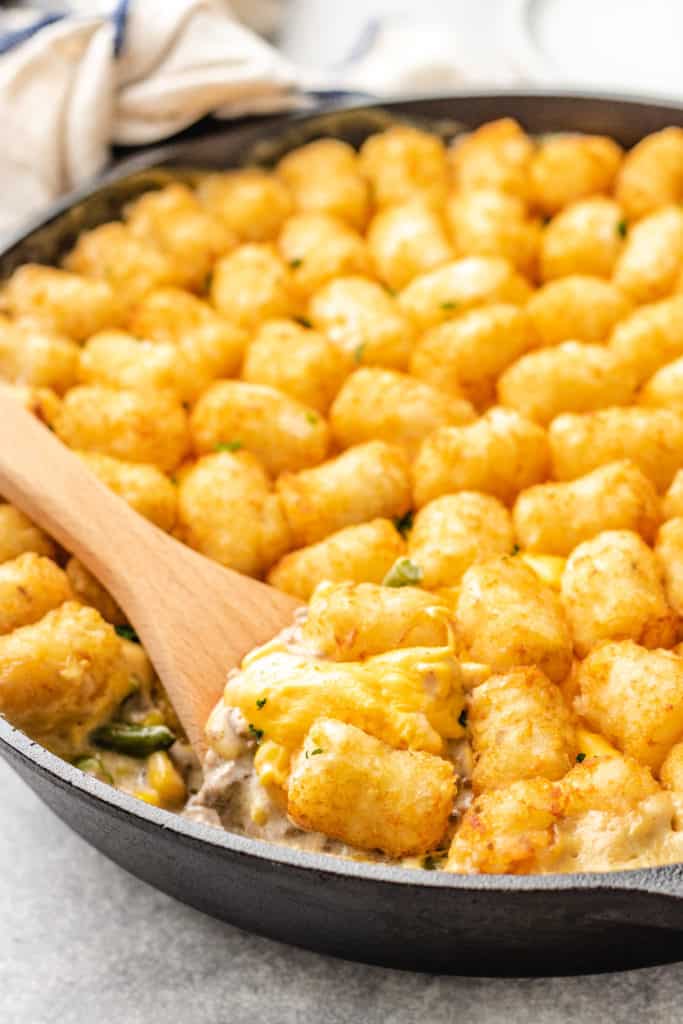 Side view of tater tot casserole in cast iron.