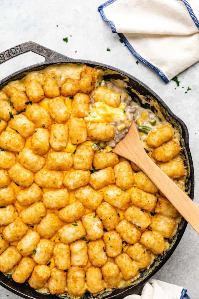 Cheesy hamburger and potato puff casserole in a pan.