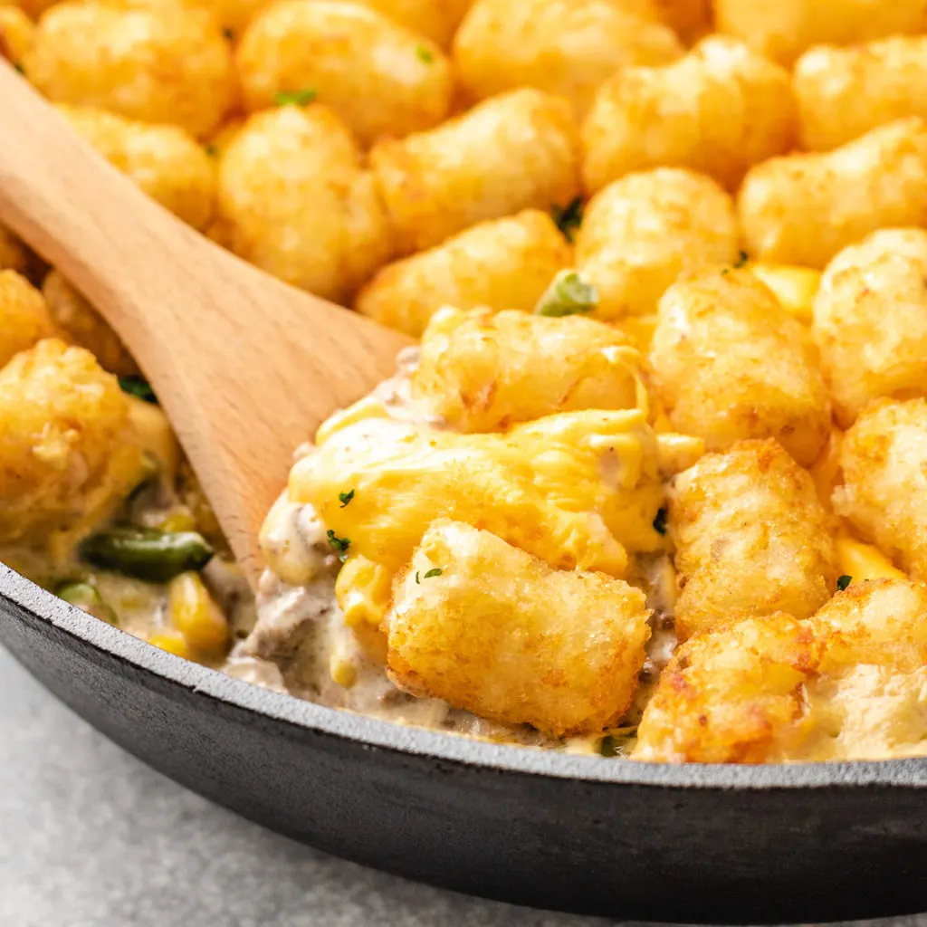 Close up view of tater tot casserole with corn and green beans.