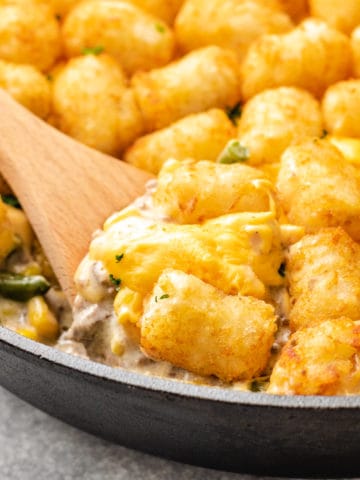 Close up view of tater tot casserole with corn and green beans.