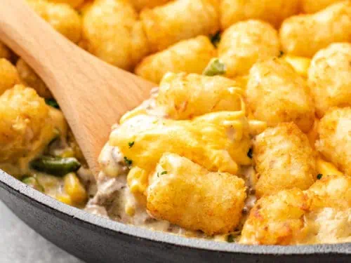 Close up view of tater tot casserole with corn and green beans.