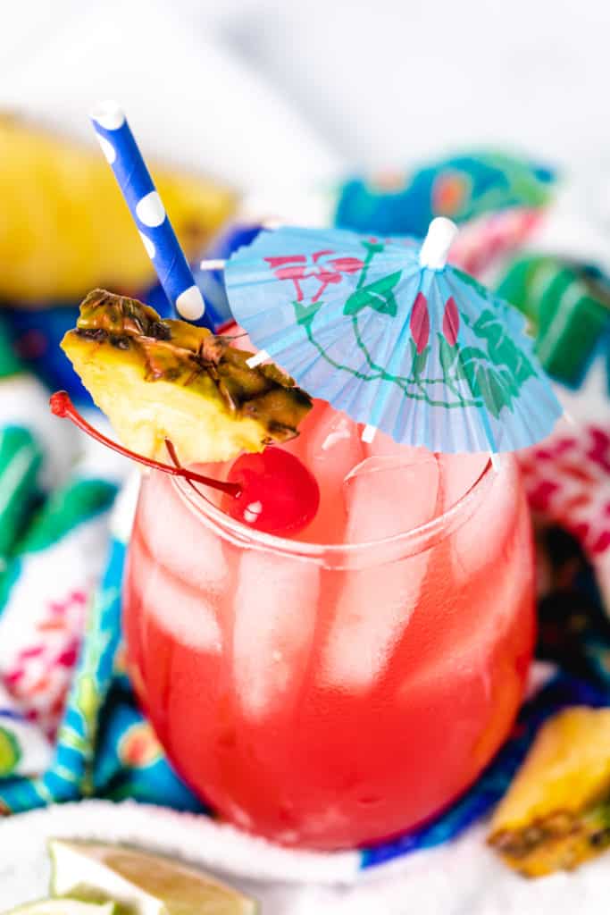 Top down view of cherries and pineapple on a beach drink.