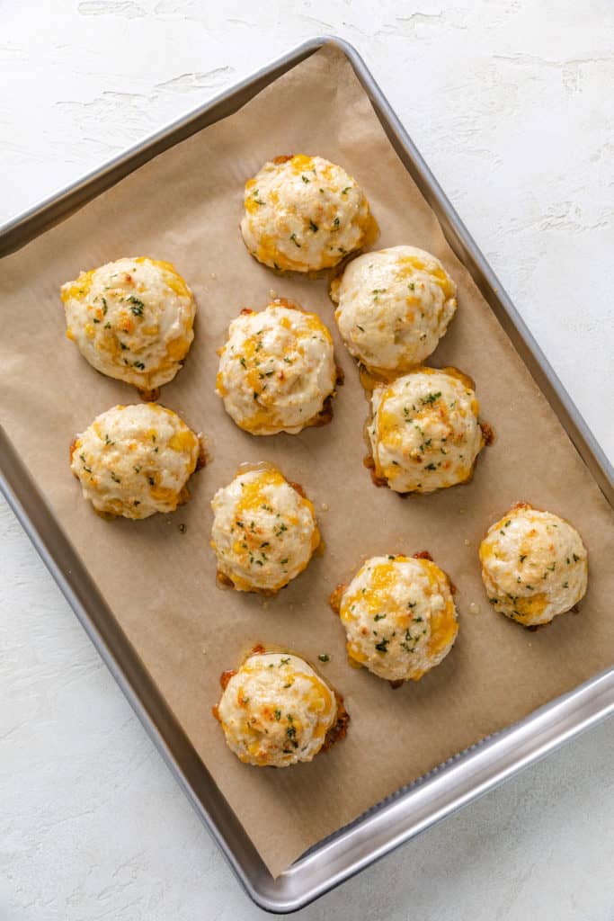 Top down view of garlic and cheese biscuits on a baking sheet.