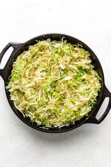 Shredded green cabbage in a pan.