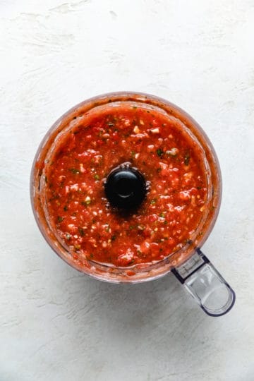 Top down view of salsa in a food processor.