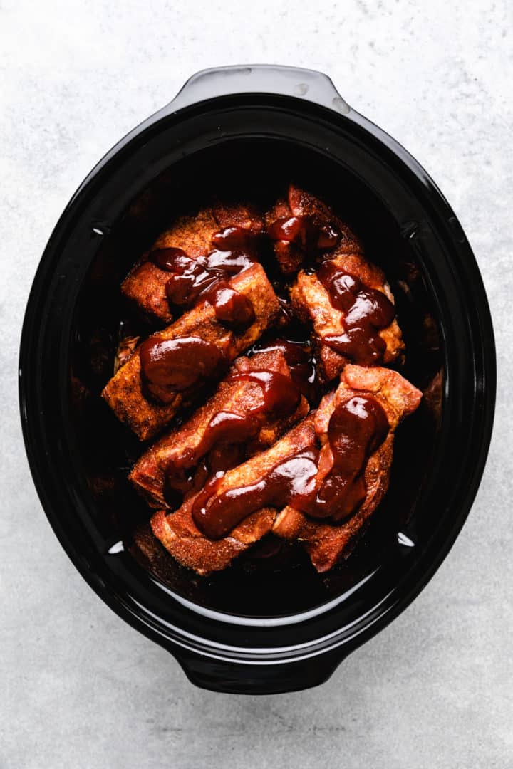 BBQ sauce on uncooked pork ribs.